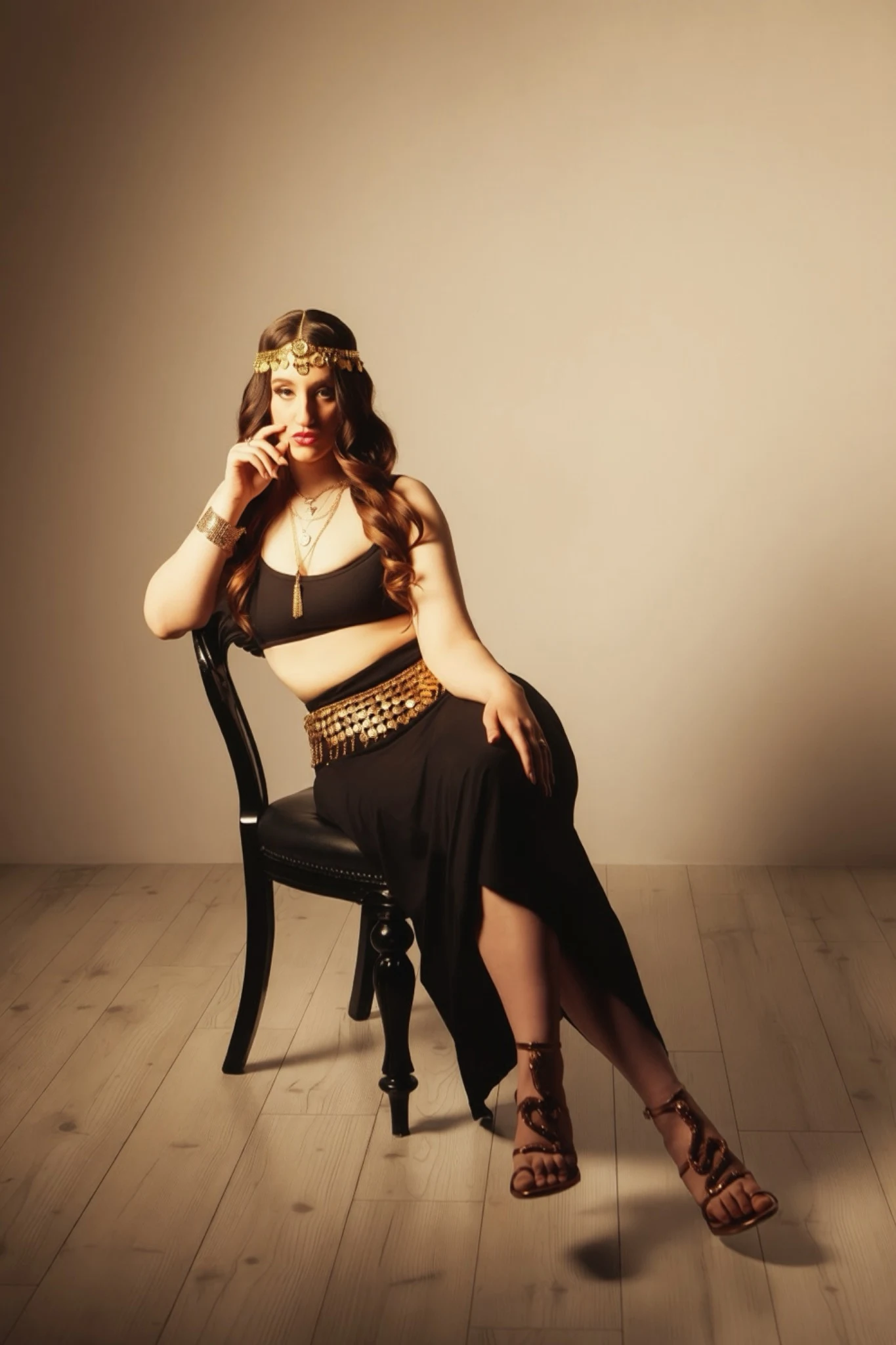 Nishka seated on a chair in black and gold