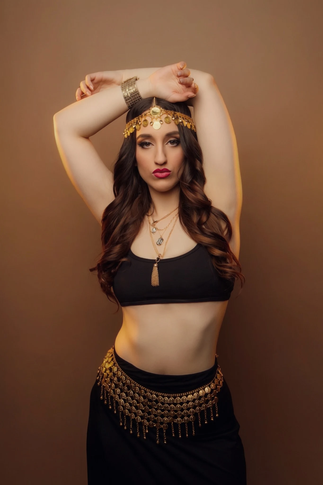 Nishka in black with her arms above her head