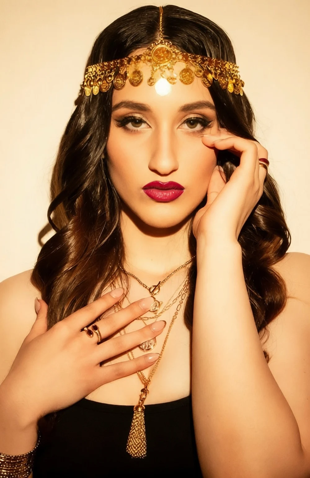 Nishka looking directly at the camera, wearing gold jewellery