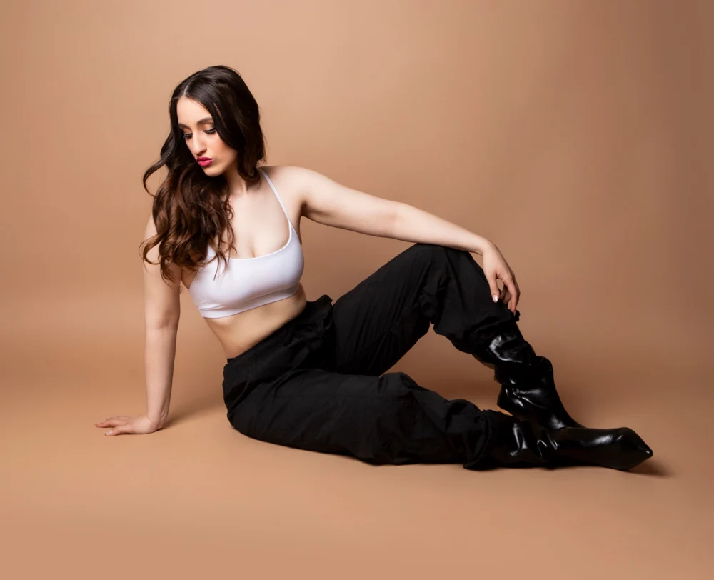 Nishka seated sideways in a white top